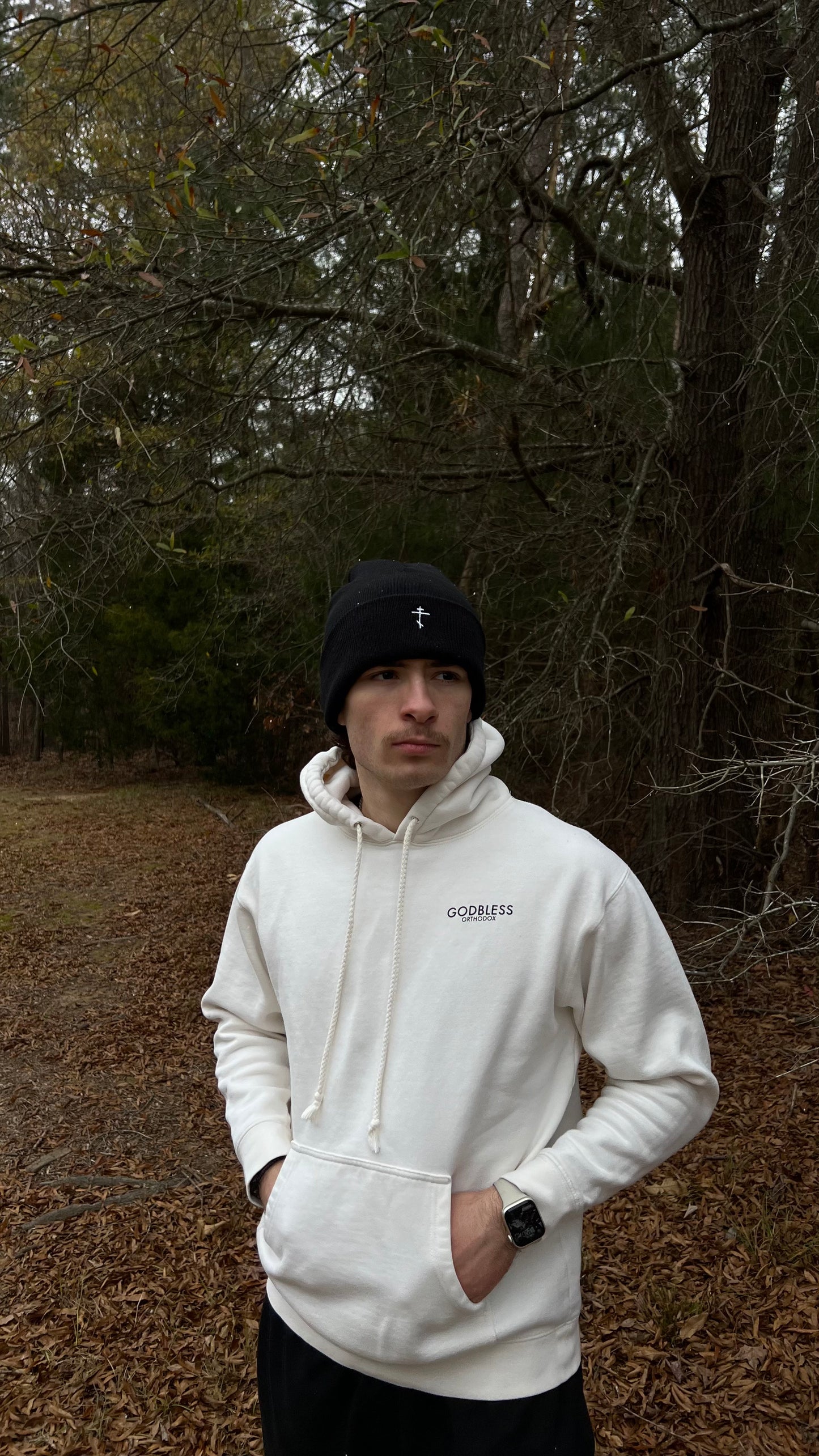 Man wearing a black Godbless Orthodox beanie and an off-white Godbless Orthodox beanie.