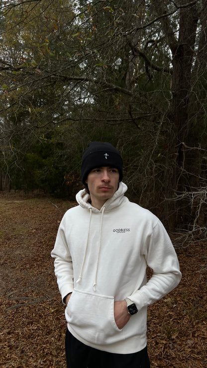 Man wearing a black Godbless Orthodox beanie and an off-white Godbless Orthodox beanie.
